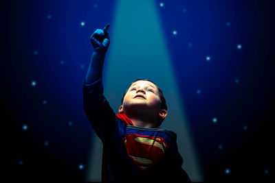 Full length of boy standing in illuminated nightclub