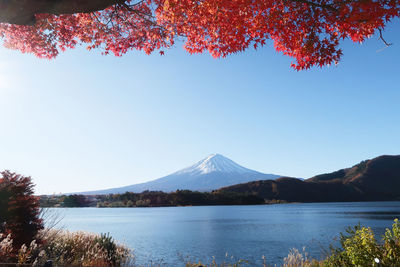 Scenic view of lake and mountains against clear blue sky