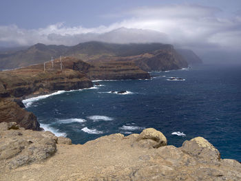 High angle view of rocky coastal feature against sky