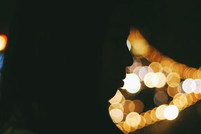 Close-up of lit candle in dark room