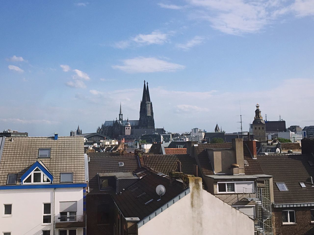 architecture, building exterior, built structure, sky, cityscape, travel destinations, roof, city, place of worship, clock tower, cloud - sky, outdoors, no people, day