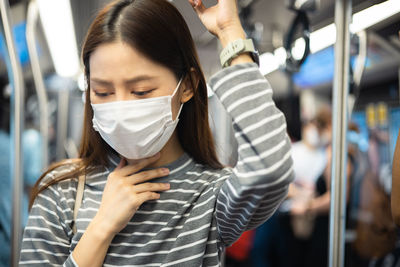 Portrait of woman holding smart phone in bus