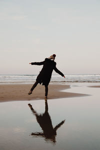 Full length of man standing on beach against sky