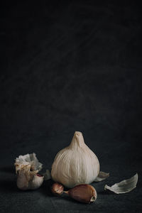 Close-up of garlic on table against black background