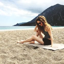 Rear view of woman sitting on beach