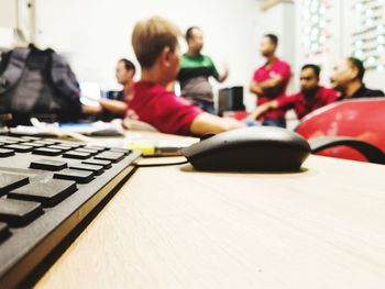 Rear view of people sitting on table