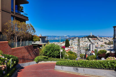 Buildings in city against clear blue sky