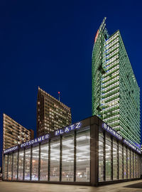 Illuminated buildings against clear sky at night