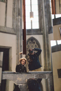 Man photographing himself and woman in a mirror