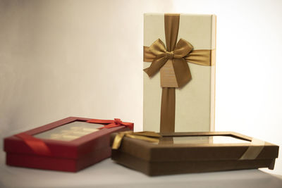 Open book on table against white wall