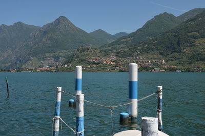 Scenic view of lake and mountains against clear blue sky