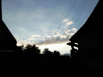 Silhouette of trees against cloudy sky