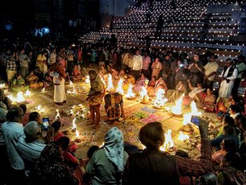 Group of people at illuminated building in city at night