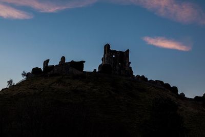 Low angle view of silhouette building against sky