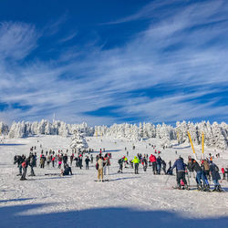 Group of people on snow against sky