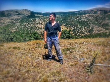 Full length of a smiling man standing on landscape