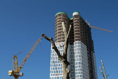 Low angle view of under construction building against clear blue sky