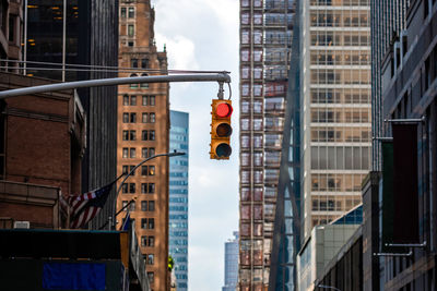 Low angle view of road signal against buildings in city