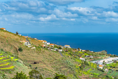 Scenic view of sea by buildings against sky