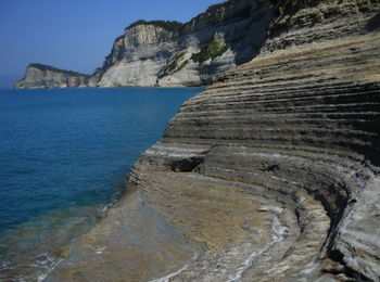 Rock formations by sea against sky