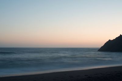 Scenic view of sea against clear sky during sunset