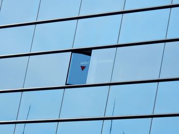 Low angle view of glass building against sky