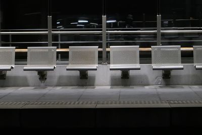 Empty seats at railroad station platform at night