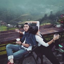 Full length of young couple sitting on seat