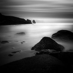 Scenic view of rocks on beach against sky
