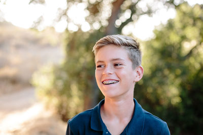 Portrait of a handsome young teen looking off and smiling outside