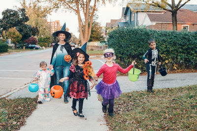 Mother with kids wearing costume standing outdoors