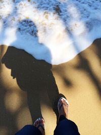 Low section of man standing on tiled floor