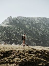 Woman standing on mountain against clear sky