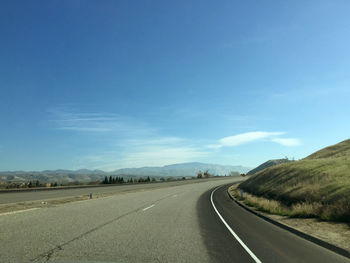 Empty road against blue sky