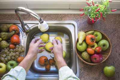 High angle view of man preparing fruits in kitchen