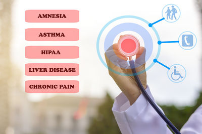 Digital composite image of doctor holding stethoscope by text against sky