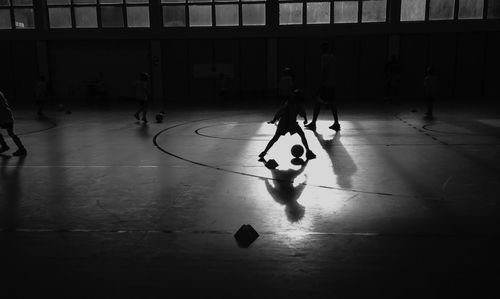 Children playing soccer indoors