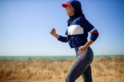 Asian woman running near sea