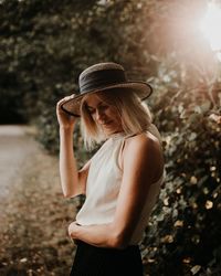 Midsection of woman wearing hat standing outdoors