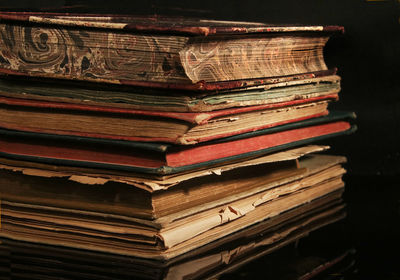 Close-up of stacked books on black background