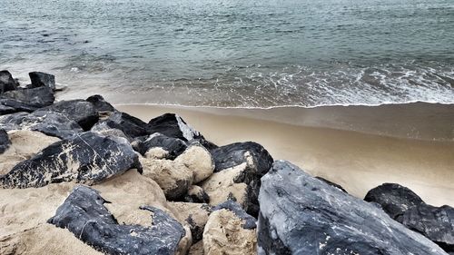 Rocks on beach against sky