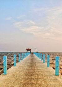 Pier on beach against sky