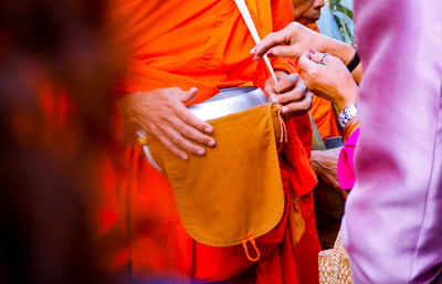 Cropped image of woman standing by monk