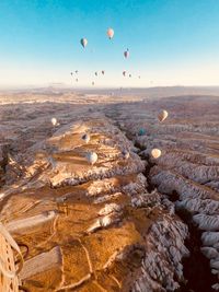 Hot air balloons flying over landscape