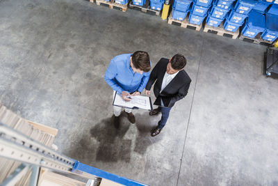 Two businessmen having a meeting in company warehouse