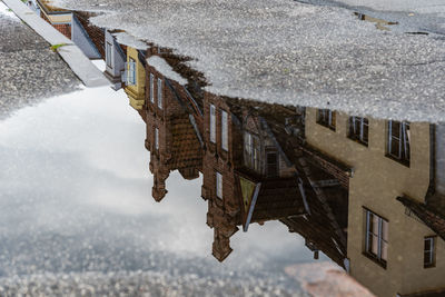 Reflection on water puddle of colorful old gable houses in historic centre of lubeck, germany.