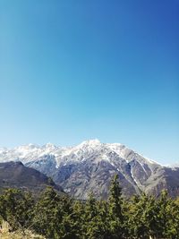 Scenic view of snowcapped mountains against blue sky