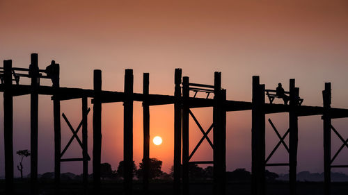 Silhouette bridge against sky during sunset