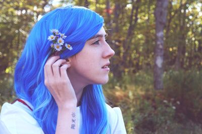 Young woman with blue dyed hair looking away