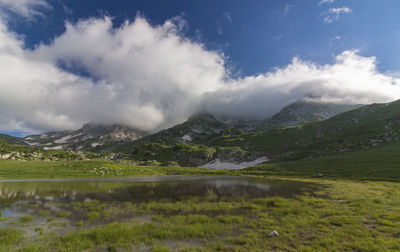 Scenic view of calm lake against mountain range